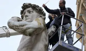 Restauratoren arbeiten auf einer Hebebühne am David von Michelangelo. Wo steht der David von Michelangelo? In Florenz, Italien.