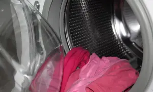 Otwarta pralka Beko z różowymi ubraniami w środku. Zastanawiasz się, jak odblokować pralkę Beko?