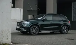 Ciemnozielony Mercedes GLE 350 stoi przed nowoczesnym budynkiem.