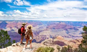 Paar bestaunt Grand Canyon. Tolle USA Reisetipps für unvergessliche Ausblicke und Abenteuer.