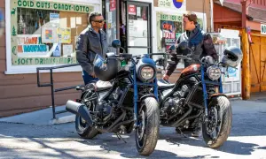 Dwóch mężczyzn w kurtkach stoi obok dwóch motocykli Honda CMX. Jeden motocykl jest czarny, drugi w kolorze miedzianym.