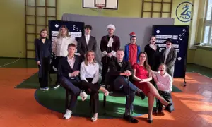 Uczniowie w strojach teatralnych, przygotowujący piosenkę absolwenta.