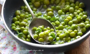 Piselli freschi in padella, cotti con cipolla e menta. Un contorno semplice e gustoso.
