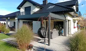 Nowoczesny pomysł na zadaszenie tarasu z huśtawką i meblami ogrodowymi. Idealne miejsce na relaks.