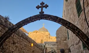 Kamienna brama z krzyżem i kopułą kościoła, jak w psalm 122, zaprasza do Jerozolimy.