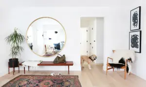 Ingresso luminoso con specchio rotondo, un cane curioso e un tappeto persiano. Trucchi per allargare una stanza con illusioni ottiche.
