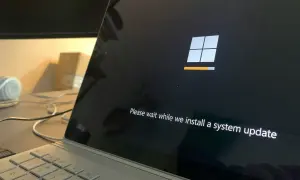 Ekran laptopa z logo Windows i paskiem postępu. System Windows 10 LTSC instaluje aktualizację.
