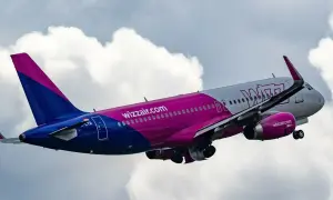 Samolot Wizzair wznosi się na tle chmur. To tanie linie lotnicze, które oferują loty po Europie.