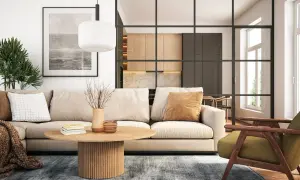 Gemütliche zimmer einrichtung mit beigem Sofa, Holztisch und grüner Sessel. Im Hintergrund offene Küche mit Holzelementen.