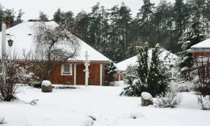 Śnieżne Boże Narodzenie na Kaszubach. Drewniane domki agroturystyki otoczone lasem i pokryte białym puchem.