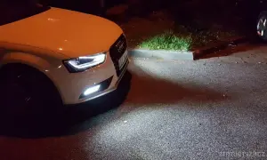 Białe Audi A4 B8 po lifcie z zapalonymi światłami przeciwmgielnymi. Wymiana żarówki przeciwmgielnej zakończona sukcesem.