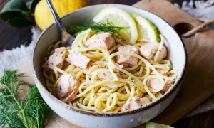Eine köstliche Pasta mit Fisch, inspiriert von italienischer Küche, serviert in einer Schüssel mit Zitronenscheiben und Dill.
