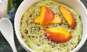 Grön smoothiebowl med avokado, toppad med persikoklyftor och hampafrön. Ett enkelt och gott avokado recept.