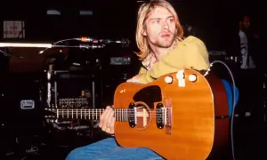 Kurt Cobain z gitarą akustyczną, symbol grunge'u i muzyki, która zdefiniowała pokolenie.