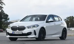 Białe BMW 118d z czarnymi felgami stoi na parkingu.
