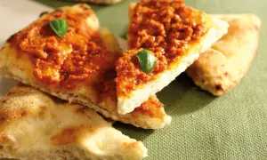 Tranches de pizza basilic, garnies d'une sauce rouge savoureuse et d'une feuille de basilic frais.