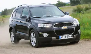 Czarny Chevrolet Captiva z kierowcą w okularach przeciwsłonecznych jedzie po piaszczystej drodze, wzbijając kurz.