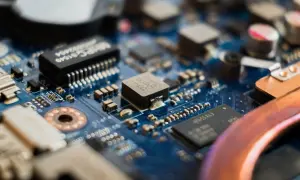 Zbliżenie na niebieską płytę główną z widocznymi elementami elektronicznymi, w tym układem **cmos**.