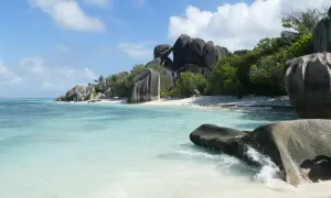 Rajska plaża na Seszelach z turkusową wodą, białym piaskiem i charakterystycznymi granitowymi skałami. Idealne miejsce na wycieczkę.