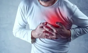 Mężczyzna trzyma się za klatkę piersiową, gdzie widoczny jest czerwony obszar bólu.