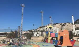 Parque infantil colorido con el Peñón de Gibraltar al fondo. ¡Un lugar ideal que hacer en Gibraltar con niños!