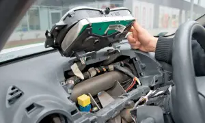 Wymiana żarówek przód w Opel Vivaro. Widok wnętrza zdemontowanego kokpitu, widoczne przewody i elementy deski rozdzielczej.