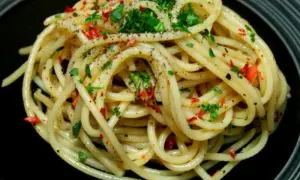 Pyszne spaghetti aglio olio, posypane natką pietruszki i płatkami chili. Idealny przepis na szybki obiad.