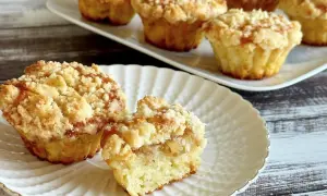 Pyszne muffinki z jabłkami, z kruszonką na wierzchu, prezentowane na białym talerzyku.