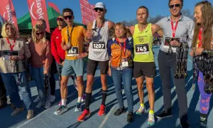 Uczestnicy biegu z medalami, zastanawiają się co zjesc przed biegiem, by osiągnąć sukces.