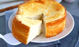 Un délicieux dessert fromage blanc rapide, un gâteau moelleux et doré, une part est déjà servie.