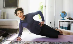 Frau macht seitlichen Unterarmstütz auf einer Matte. Nach dem Training gibt es gesunde exercise snacks.