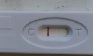 Test ciążowy z widocznym zarysem drugiej kreski. Czekam na cud.