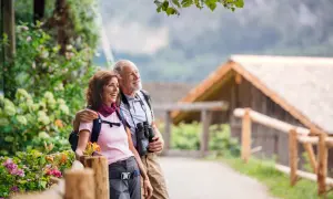 Szczęśliwi seniorzy na szlaku, odkrywający piękno natury. Idealne tanie wczasy dla seniora za granicą, pełne aktywności i relaksu.