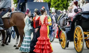 Mujeres con trajes de flamenca y caballos, evocando de donde proviene el flamenco.