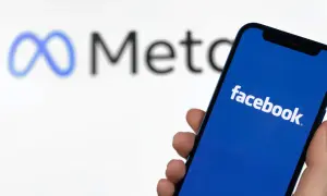 Szukasz sposobu, jak znaleźć osobę na FB po imieniu? Smartfon z logo Facebooka i symbolem Meta w tle.