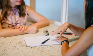 Twee vrouwen bespreken papieren. Mogelijk gaat het over de hsp therapie vergoeding.