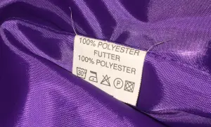 Metka z napisem "100% POLYESTER FUTTER" na fioletowej, błyszczącej podszewce. Czy poliester grzeje? Ta podszewka jest cienka, więc raczej nie zapewni ciepła.