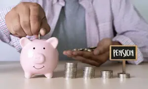 Oszczędzanie na emeryturę pomostową: ręka wrzuca monetę do świnki skarbonki, obok stosy monet i tabliczka z napisem "PENSION".