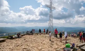 Ludzie odpoczywają na szczycie Tarnicy, podziwiając widoki. To pewnie najładniejszy szlak na Tarnicę, pełen kamieni i pięknych krajobrazów.
