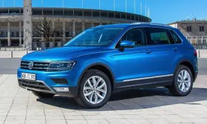 Niebieski VW Tiguan Allspace parkuje przed stadionem.