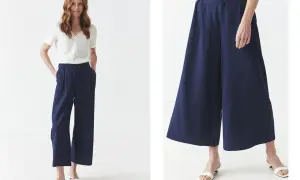 Kobieta w granatowych kulotach i białej bluzce prezentuje stylowe, letnie kuloty stylizacje.