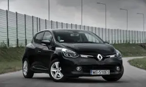 Czarny Renault Clio 4 z 2013 roku na drodze, z barierą dźwiękochłonną w tle.