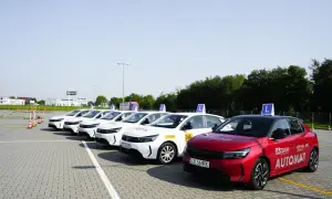 Rząd białych i jeden czerwony samochód szkoleniowy z literą "L" na dachu, gotowe do nauki jazdy i zdobycia nowego prawo jazdy.