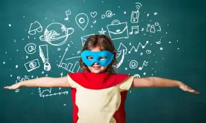 Dziecko w stroju superbohatera, z maską na oczach, symbolizuje rozwój emocjonalny dziecka. Na tablicy rysunki symbolizujące naukę i sukces.