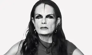 Black and white portrait of Michèle Lamy with dramatic eye makeup and a line drawn on her forehead.