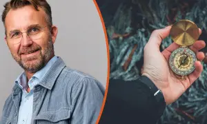 Man med glasögon och kompass i handen, symbol för att navigera i en VUCA-värld.