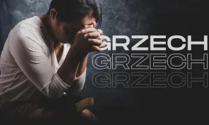Kobieta z dłońmi złożonymi do modlitwy nad Biblią, zastanawiająca się, co to jest grzech ciężki.