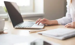Persona trabajando en portátil, ideal para buscar como saber cuantas pulgadas tiene mi portatil.