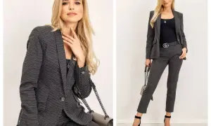 Elegancki damski casual dress code: kobieta w grafitowym garniturze w drobny wzór, z czarną bluzką i torebką.