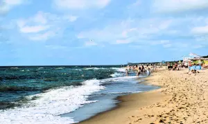 Plaża w Dąbkach tętni życiem. Ludzie kąpią się w morzu, spacerują brzegiem, a na piasku odpoczywają. To idealne miejsce na wakacyjne atrakcje.